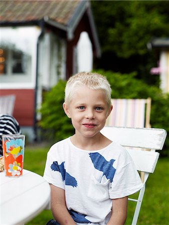 simsearch:6102-06965682,k - Portrait of boy sitting at outdoor table Photographie de stock - Premium Libres de Droits, Code: 6102-06965474