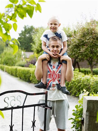 Teenage boy carrying younger brother on shoulders Photographie de stock - Premium Libres de Droits, Code: 6102-06965480