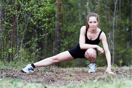 simsearch:6102-06965774,k - Young woman stretching in forest Stock Photo - Premium Royalty-Free, Code: 6102-06965786