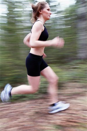 female jogger side view - Young woman running through forest Stock Photo - Premium Royalty-Free, Code: 6102-06965789