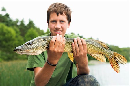 simsearch:6102-03866566,k - Smiling teenage boy with caught fish Foto de stock - Sin royalties Premium, Código: 6102-07158167