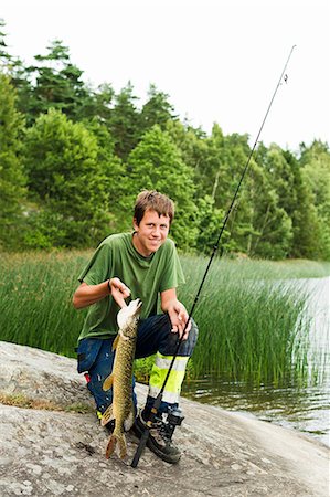 simsearch:6102-03867416,k - Smiling teenage boy with caught fish Stock Photo - Premium Royalty-Free, Code: 6102-07158168