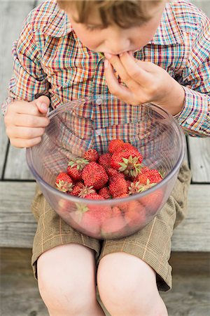 Boy eating strawberry Photographie de stock - Premium Libres de Droits, Code: 6102-07158171