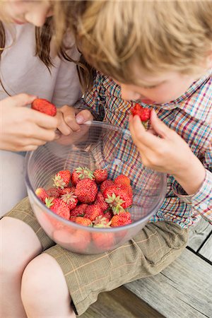 simsearch:6102-07158240,k - Boy and girl eating strawberry Stock Photo - Premium Royalty-Free, Code: 6102-07158172