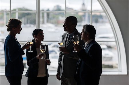 simsearch:6102-07157992,k - Businesspeople talking while having glass of wine Photographie de stock - Premium Libres de Droits, Code: 6102-07158214