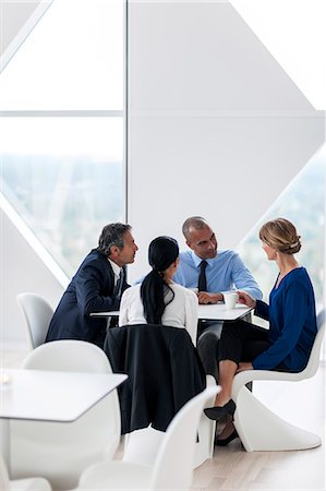 simsearch:6102-07843684,k - Businessman and businesswomen talking while drinking coffee Foto de stock - Sin royalties Premium, Código: 6102-07158218