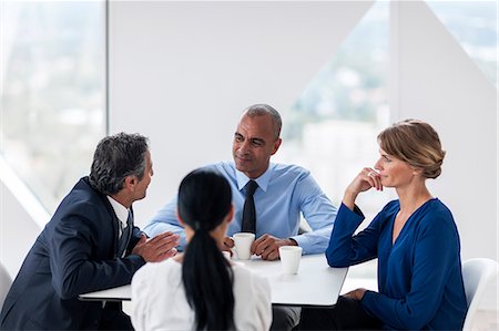 simsearch:6102-07843684,k - Businessman and businesswomen talking while drinking coffee Foto de stock - Sin royalties Premium, Código: 6102-07158225