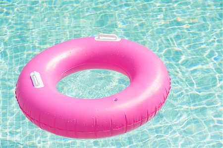 Pink inflatable ring floating at swimming pool Stock Photo - Premium Royalty-Free, Code: 6102-07158336