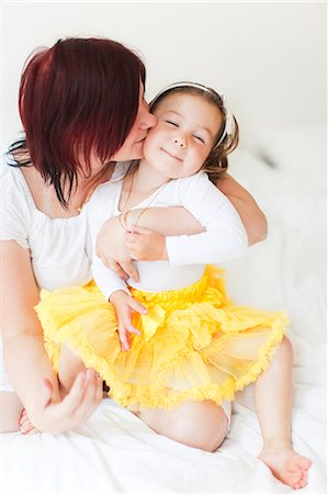 Happy mother with daughter sitting on bed Stock Photo - Premium Royalty-Free, Code: 6102-07455778