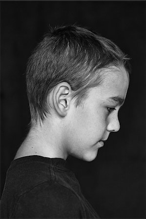 portrait black background - Profile of boy, studio shot Stock Photo - Premium Royalty-Free, Code: 6102-07602481