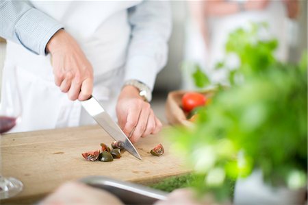 Hands cutting vegetable on cutting board Stock Photo - Premium Royalty-Free, Code: 6102-07602677