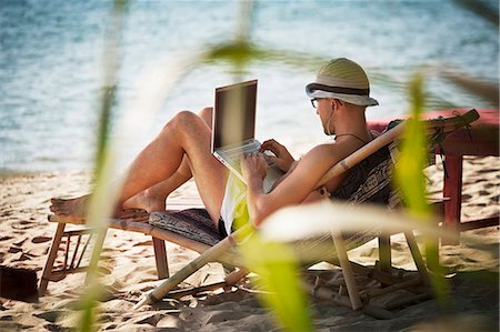 Man on beach using laptop Stock Photo - Premium Royalty-Free, Code: 6102-07602776