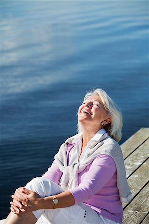 simsearch:6102-07602696,k - Smiling senior woman sitting on jetty, Bohuslan, Sweden Fotografie stock - Premium Royalty-Free, Codice: 6102-07602713