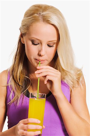 simsearch:6102-07769056,k - Young woman in sports clothes drinking juice, studio shot Stock Photo - Premium Royalty-Free, Code: 6102-07768418