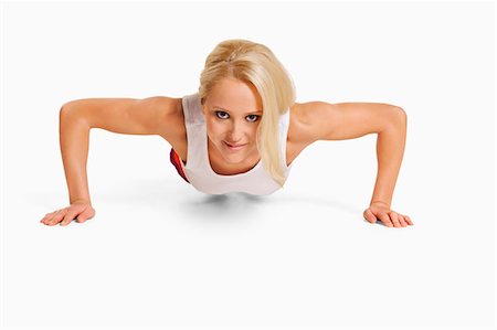 pushup woman - Smiling young woman training, studio shot Stock Photo - Premium Royalty-Free, Code: 6102-07768421