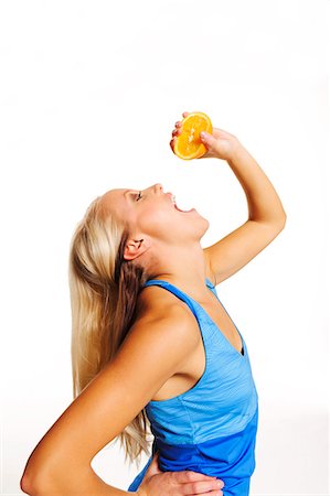 fruits and vegetables white background - Young woman with orange, studio shot Stock Photo - Premium Royalty-Free, Code: 6102-07768425