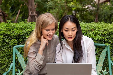 simsearch:400-04835760,k - Young women on park bench using laptop, Thailand Foto de stock - Sin royalties Premium, Código: 6102-07768878