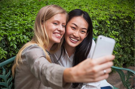 simsearch:400-04835760,k - Young women on park taking pictures with smartphone, Thailand Foto de stock - Sin royalties Premium, Código: 6102-07768879