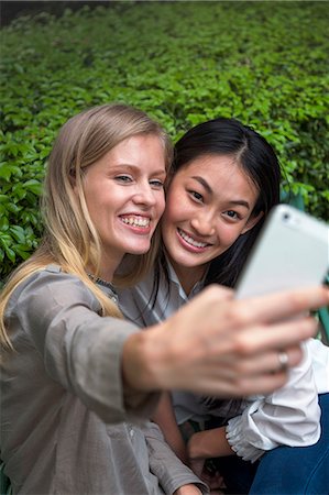 simsearch:400-04835760,k - Young women on park taking pictures with smartphone, Thailand Foto de stock - Sin royalties Premium, Código: 6102-07768880
