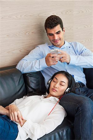 simsearch:6102-07768969,k - Young couple sitting on sofa, Bangkok, Thailand Foto de stock - Royalty Free Premium, Número: 6102-07768946