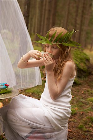 Girl wearing fern wreath having tea in forest Stock Photo - Premium Royalty-Free, Code: 6102-07769252