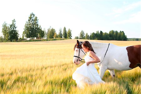 simsearch:6102-08996323,k - Woman with horse on field Photographie de stock - Premium Libres de Droits, Code: 6102-07769416