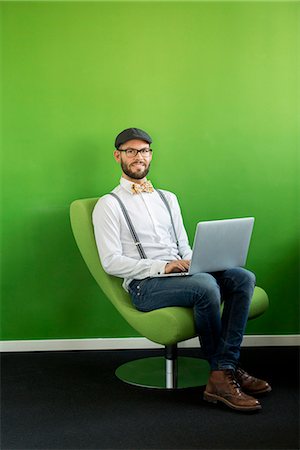 sitting room with people sitting - Man working on laptop Stock Photo - Premium Royalty-Free, Code: 6102-07789695