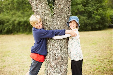 simsearch:6126-09267387,k - Boy and girl hugging tree Photographie de stock - Premium Libres de Droits, Code: 6102-07789798