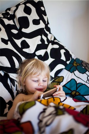 Girl in bed using digital tablet Stock Photo - Premium Royalty-Free, Code: 6102-07789721