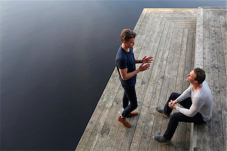 friend talking outdoors not children not bathing suit not school not beach not business - Two men talking on jetty Foto de stock - Sin royalties Premium, Código: 6102-07789937