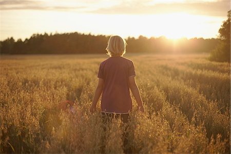 simsearch:6102-08858730,k - Boy standing on field at dusk Stock Photo - Premium Royalty-Free, Code: 6102-07790021