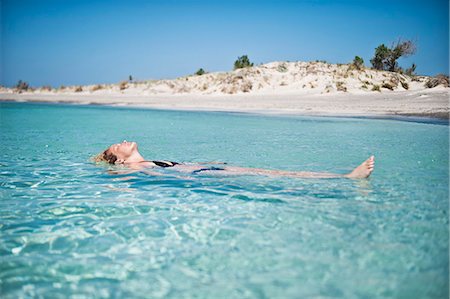 Woman floating on water Stock Photo - Premium Royalty-Free, Code: 6102-07790140