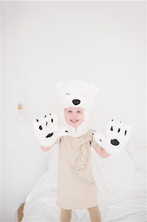 simsearch:6102-07842733,k - Girl wearing polar bear costume standing on bed Foto de stock - Royalty Free Premium, Número: 6102-07842734