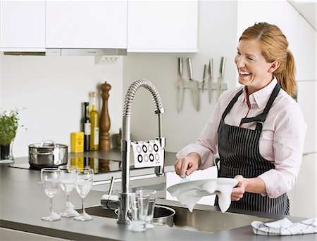 simsearch:6102-05655515,k - Smiling woman washing dishes Stockbilder - Premium RF Lizenzfrei, Bildnummer: 6102-07842894