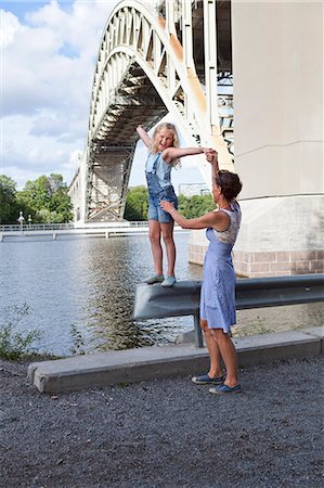 simsearch:6102-07843044,k - Mother assisting daughter on fence Photographie de stock - Premium Libres de Droits, Code: 6102-07842985