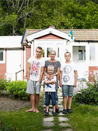 simsearch:6102-06470809,k - Mother and three sons standing in front of weekend cottage Photographie de stock - Premium Libres de Droits, Code: 6102-07842915