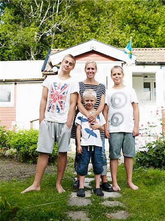 simsearch:6102-06470809,k - Mother and three sons standing in front of weekend cottage Photographie de stock - Premium Libres de Droits, Code: 6102-07842916