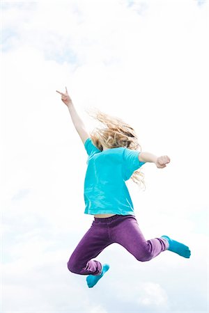 Girl jumping, low angle view Stock Photo - Premium Royalty-Free, Code: 6102-07842928