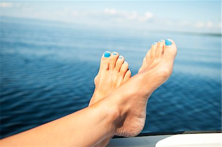 simsearch:6102-07768749,k - Womans feet with blue nail polish, sea in background Photographie de stock - Premium Libres de Droits, Code: 6102-07843335