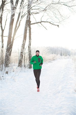 simsearch:6102-07843104,k - Mid adult man running at winter Photographie de stock - Premium Libres de Droits, Code: 6102-07843421