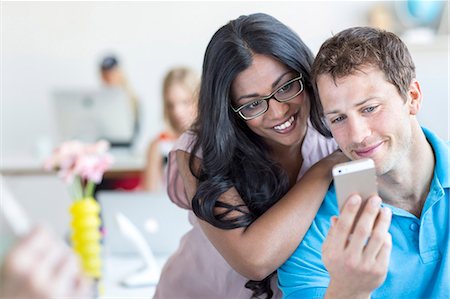 simsearch:6102-07843687,k - Young couple looking at cell phone Stock Photo - Premium Royalty-Free, Code: 6102-07843689