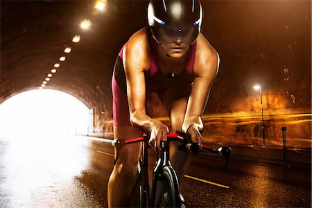 simsearch:6102-03904918,k - Woman cycling through tunnel Foto de stock - Royalty Free Premium, Número: 6102-07843608