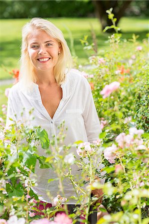 single rose - Smiling woman in garden Stock Photo - Premium Royalty-Free, Code: 6102-07843701