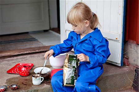 Girl playing with mud on doorstep Photographie de stock - Premium Libres de Droits, Code: 6102-07843720