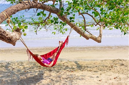 Young woman relaxing in hammock on beach Stock Photo - Premium Royalty-Free, Code: 6102-07843873