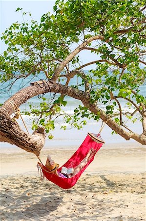 Young woman relaxing in hammock on beach Stock Photo - Premium Royalty-Free, Code: 6102-07843872
