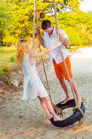 simsearch:400-05097844,k - Young couple swinging on beach Stock Photo - Premium Royalty-Free, Code: 6102-07843893