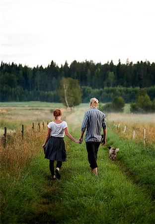 romantic hairstyle - Young couple walking through grassy road Stock Photo - Premium Royalty-Free, Code: 6102-07843814