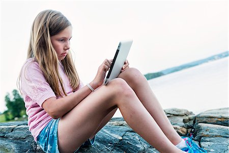 Girl using digital tablet Stock Photo - Premium Royalty-Free, Code: 6102-07844080