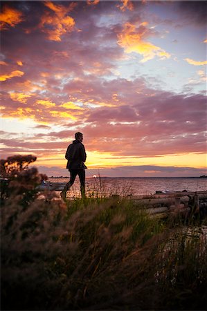sunset lonely men - Man walking at sunset Stock Photo - Premium Royalty-Free, Code: 6102-07844143